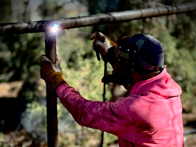 Technician welding while crouched on-site